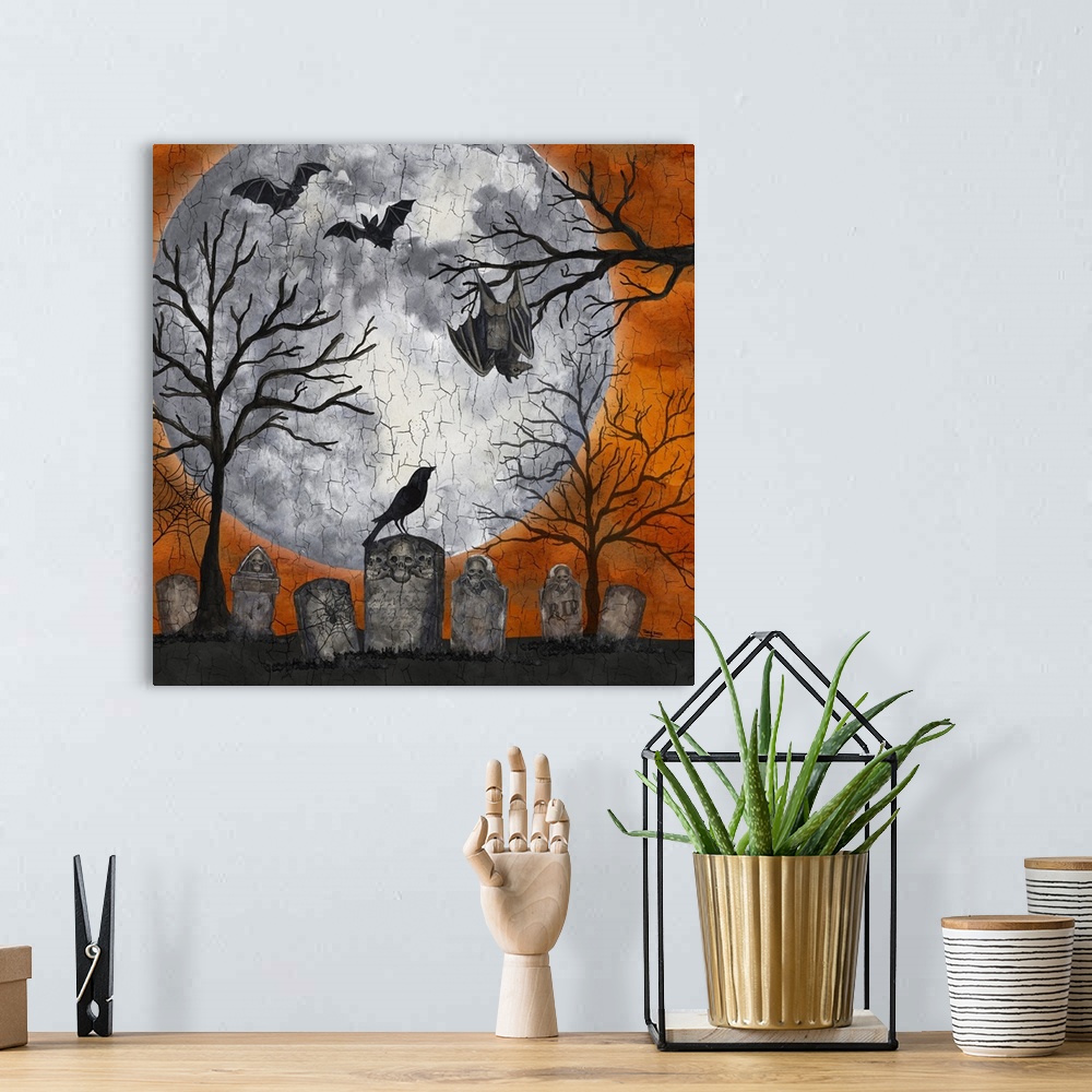 A bohemian room featuring A square decorative image of a graveyard scene with bats, a large moon and an orange sky.
