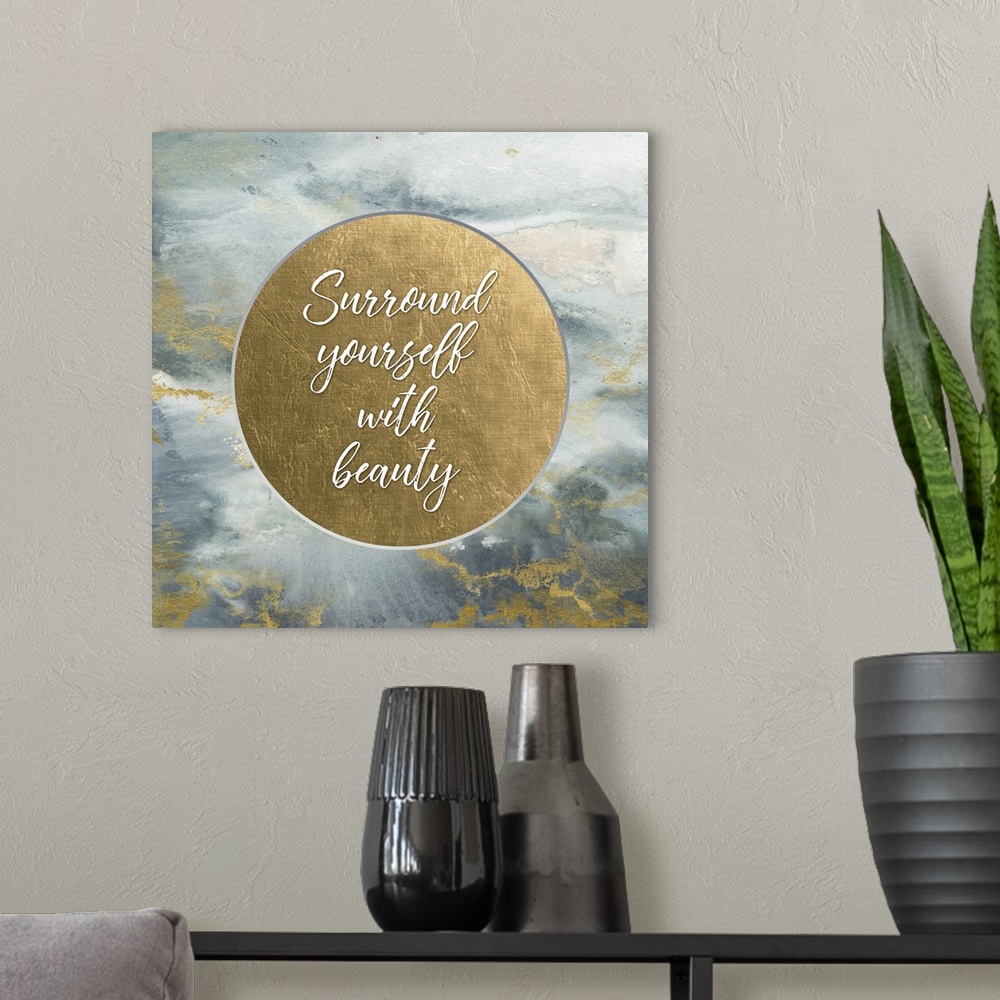 A modern room featuring "Surround yourself with beauty" on a metallic gold circle on a marbled gray and gold background.