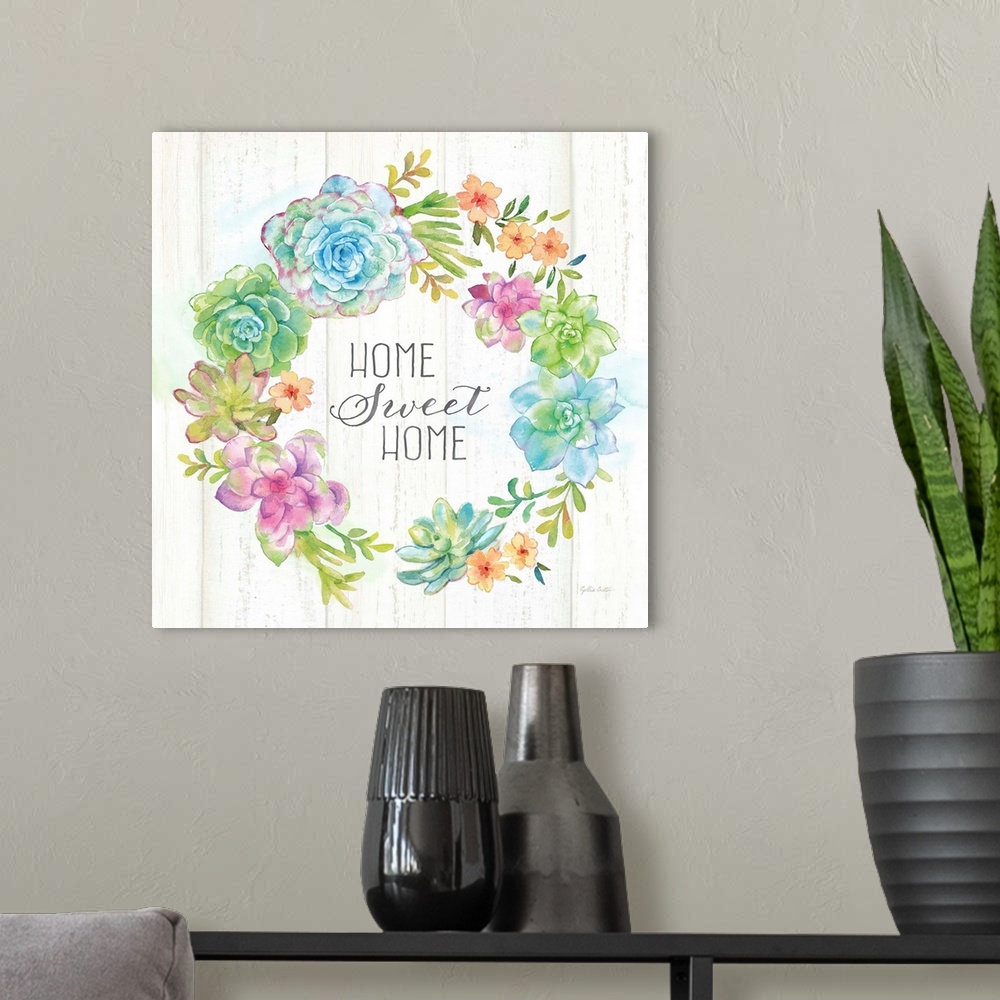 A modern room featuring "Home Sweet Home" on a square decorative watercolor painting of a wreath of colorful succulents.