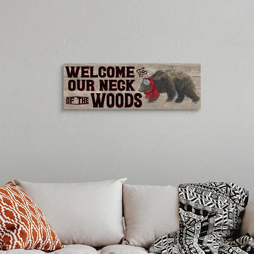 A bohemian room featuring Decorative image of 'Welcome To Our Neck Of The Woods' with a brown bear wearing ear muffs and a ...