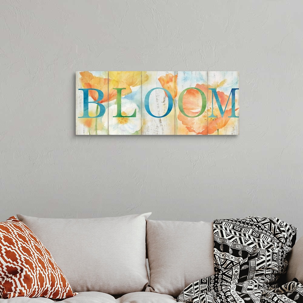 A bohemian room featuring "Bloom" in blue and green over a watercolor image of white, orange and yellow flowers with a wood...