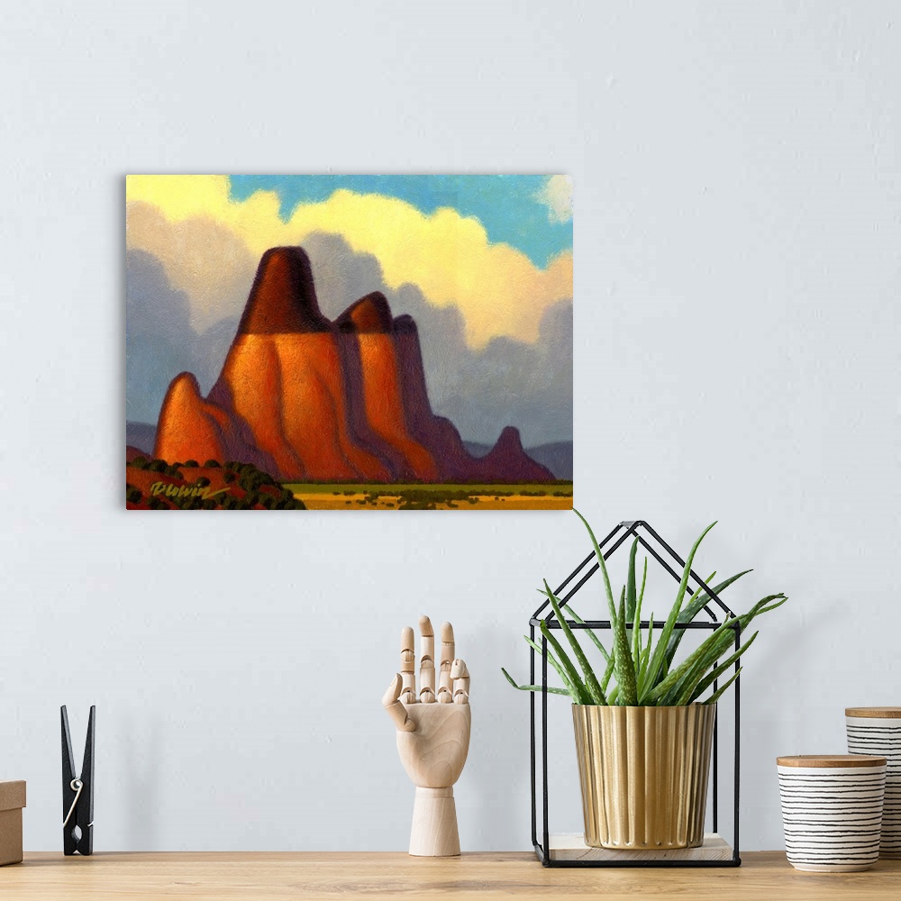 A bohemian room featuring Landscape painting of a desert butte with bright clouds.