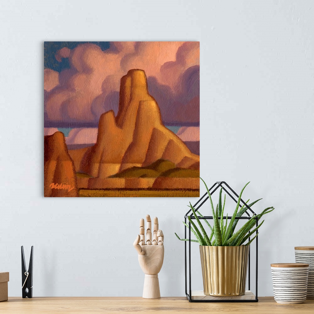 A bohemian room featuring Square landscape painting of large canyons with pink fluffy clouds above.