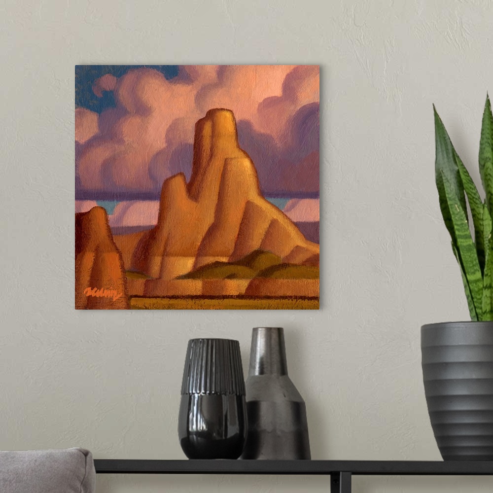 A modern room featuring Square landscape painting of large canyons with pink fluffy clouds above.