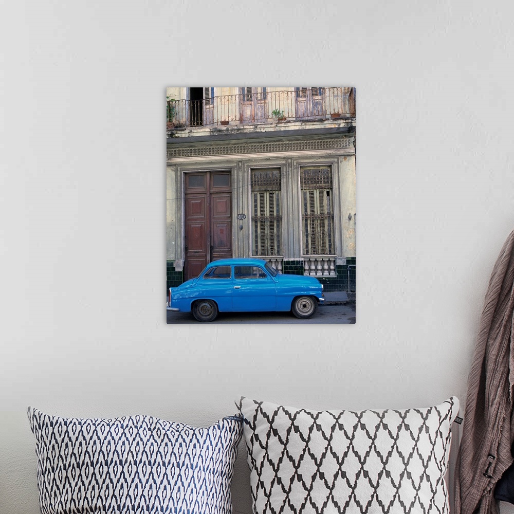 A bohemian room featuring A blue car parked outside a shabby house in Old Havana, Cuba, West Indies