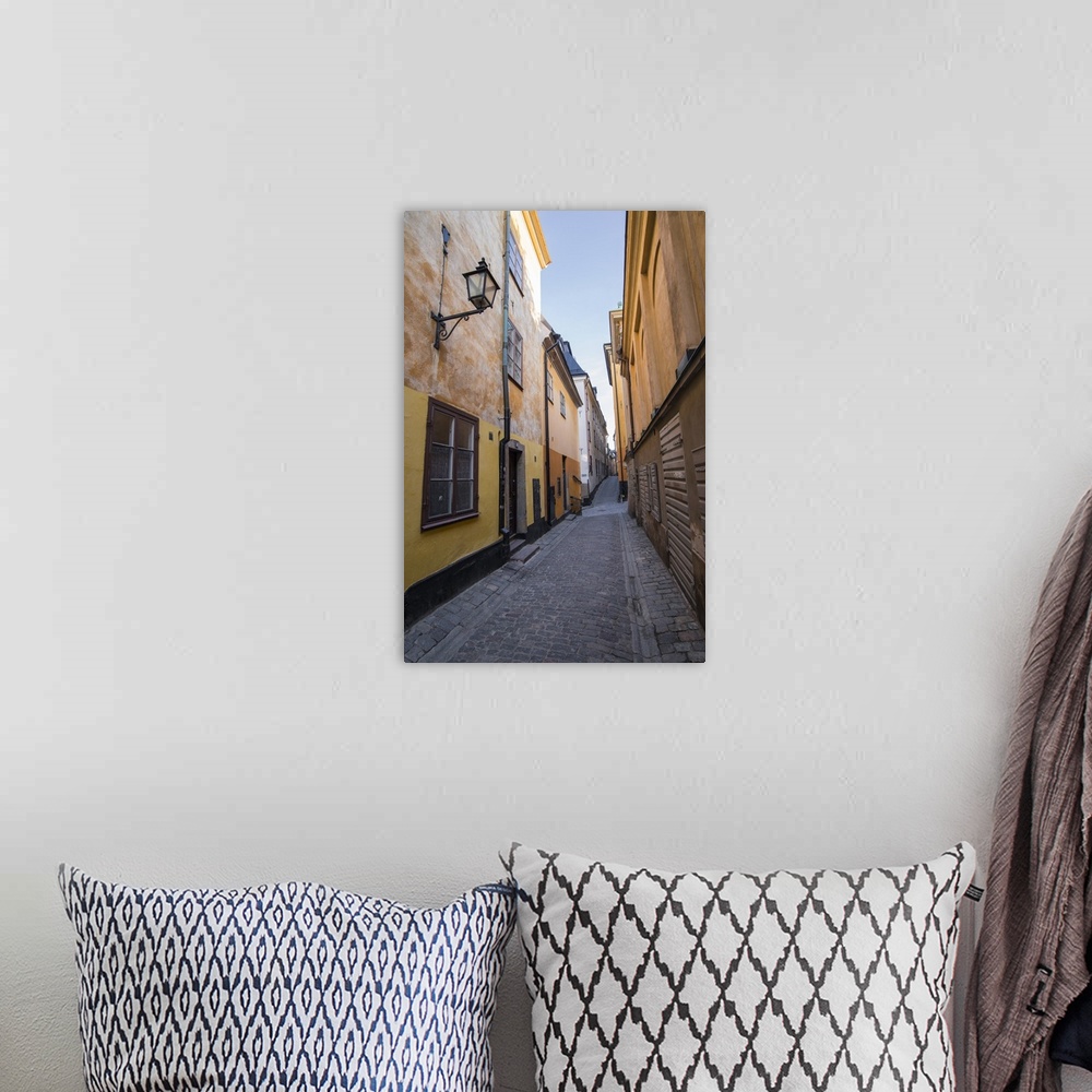A bohemian room featuring A pedestrian walks the streets of Stockholm's colorful and historic Gamla Stan district, Stockhol...