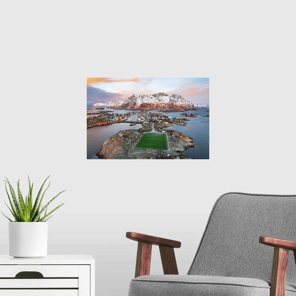 A modern room featuring Aerial view of soccer stadium and Henningsvaer village during winter dawn, Nordland county, Lofot...
