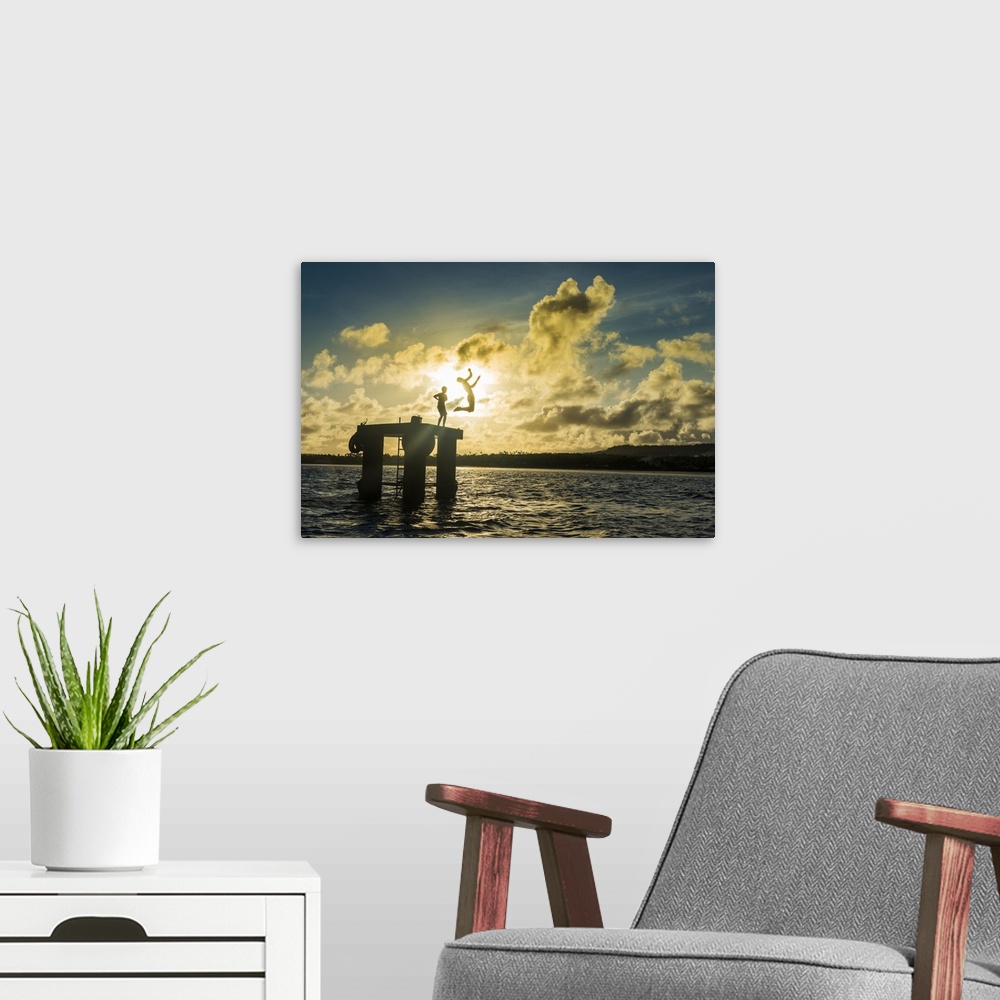 A modern room featuring Backlit local boys jumping into the water of the lagoon of Wallis from a platform, Wallis and Fut...