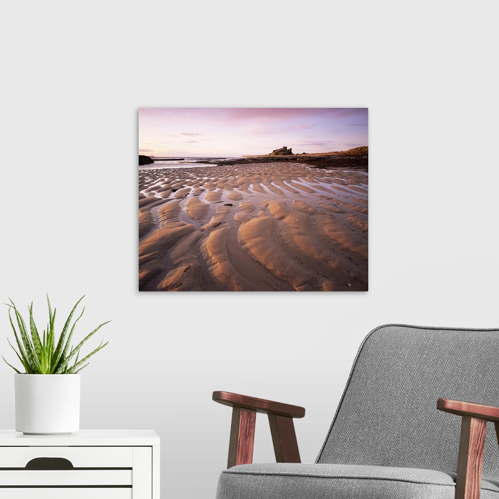 A modern room featuring Bamburgh castle and beach at sunrise, Bamburgh, Northumberland, England