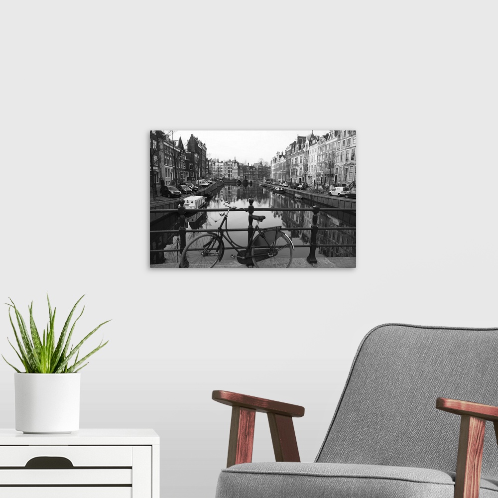 A modern room featuring Black and white imge of an old bicycle by the Singel canal, Amsterdam, Netherlands