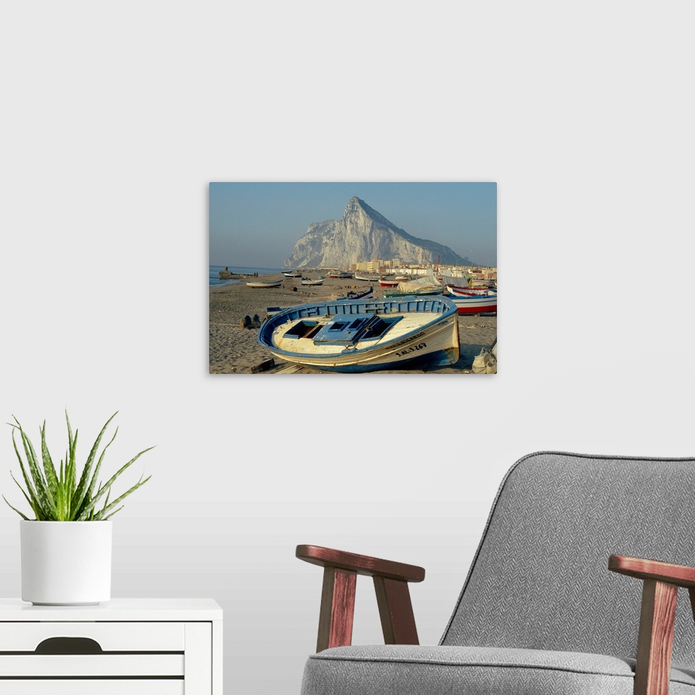 A modern room featuring Boats pulled onto beach below the Rock of Gibraltar, Gibraltar
