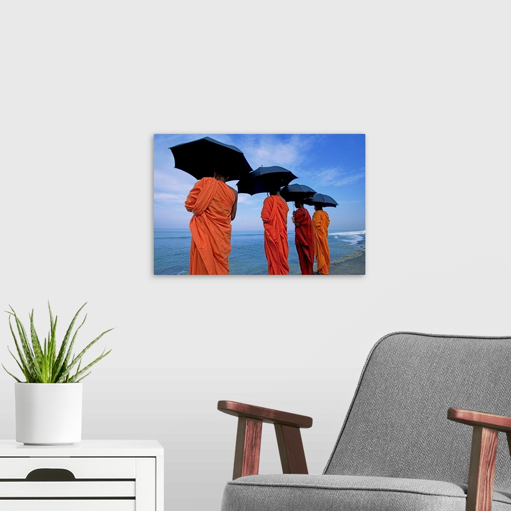 A modern room featuring Buddhist monks watching the Indian Ocean, Colombo, island of Sri Lanka, Asia