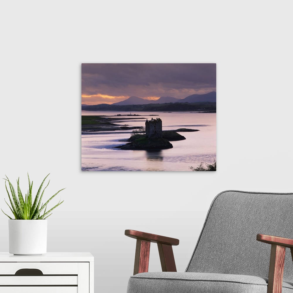 A modern room featuring Castle Stalker on Loch Linnhe, silhouetted at dusk, Argyll, Scotland, UK