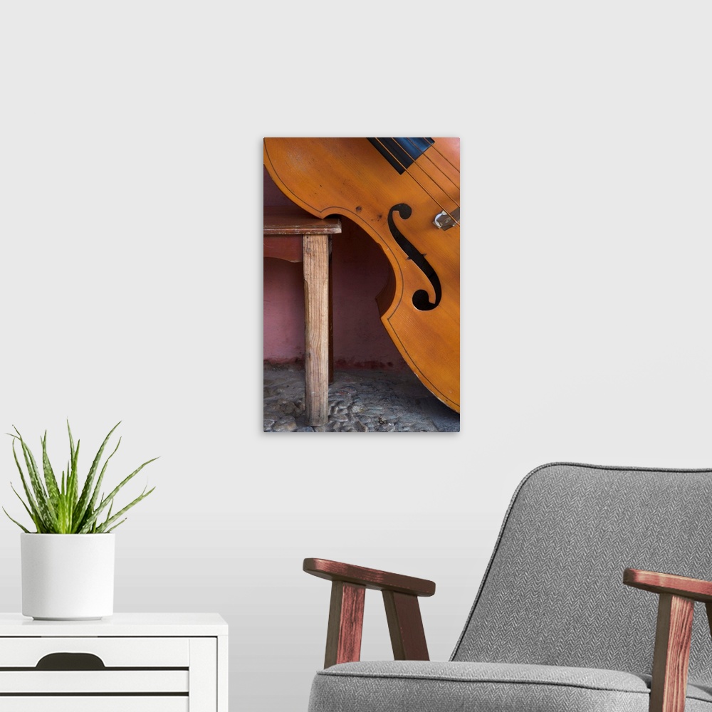 A modern room featuring Close-up of a counterbass leaning against a wooden table, Trinidad, Cuba
