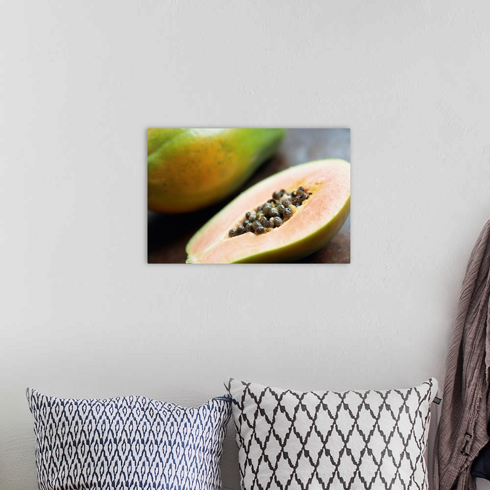 A bohemian room featuring Close-up of a papaya sliced in half showing black seeds inside