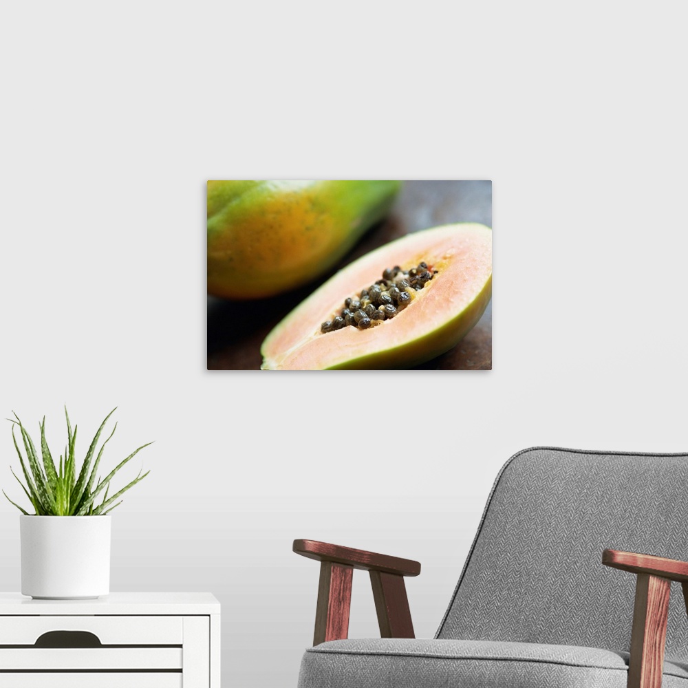 A modern room featuring Close-up of a papaya sliced in half showing black seeds inside