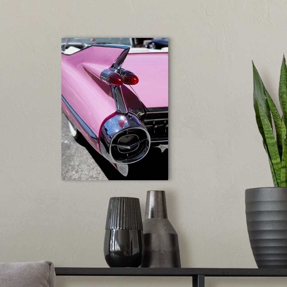 A modern room featuring Close-up of fin and lights on a pink Cadillac car