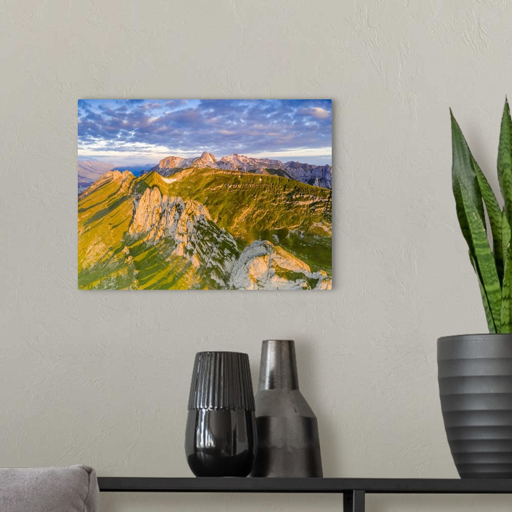 A modern room featuring Clouds at dawn over the majestic Santis and Saxer Lucke mountains, aerial view, Appenzell Canton,...