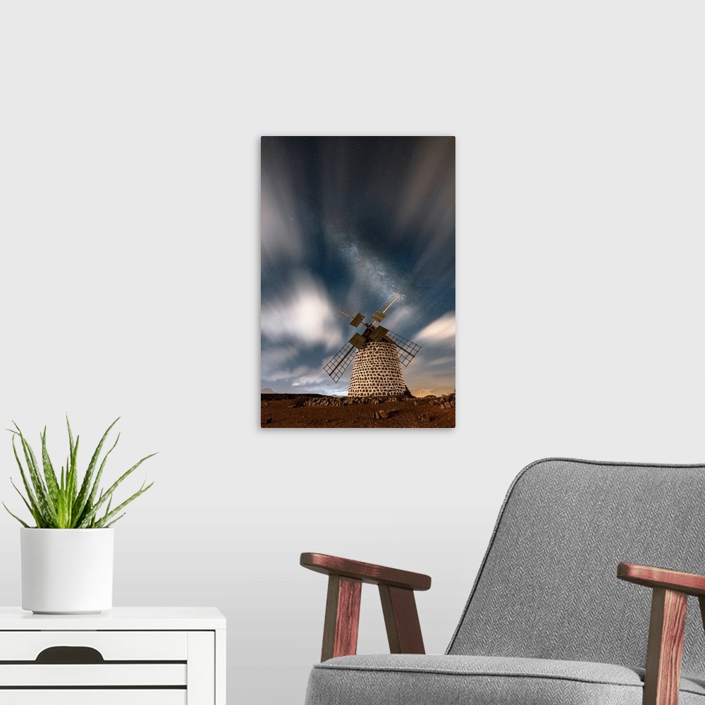 A modern room featuring Long exposure image of clouds in the night sky over the old windmill, La Oliva, Fuerteventura, Ca...