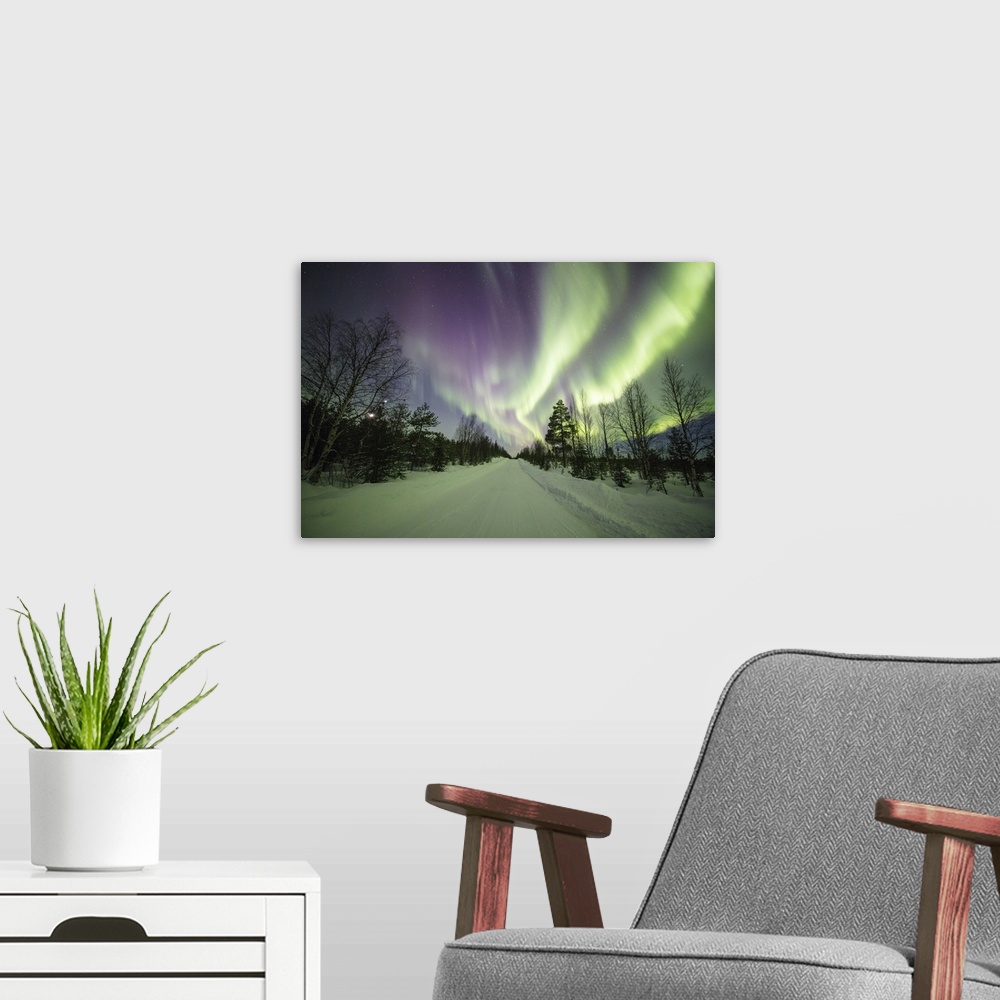 A modern room featuring Colorful lights of the Northern Lights and starry sky on the snowy woods, Levi, Sirkka, Kittila, ...