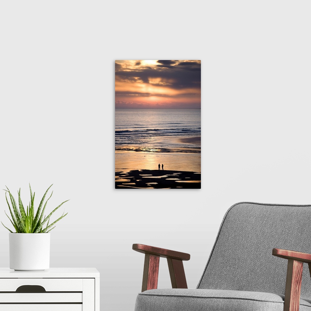 A modern room featuring Couple in silhouette looking at North Sea at sunsrise, Northumberland, England