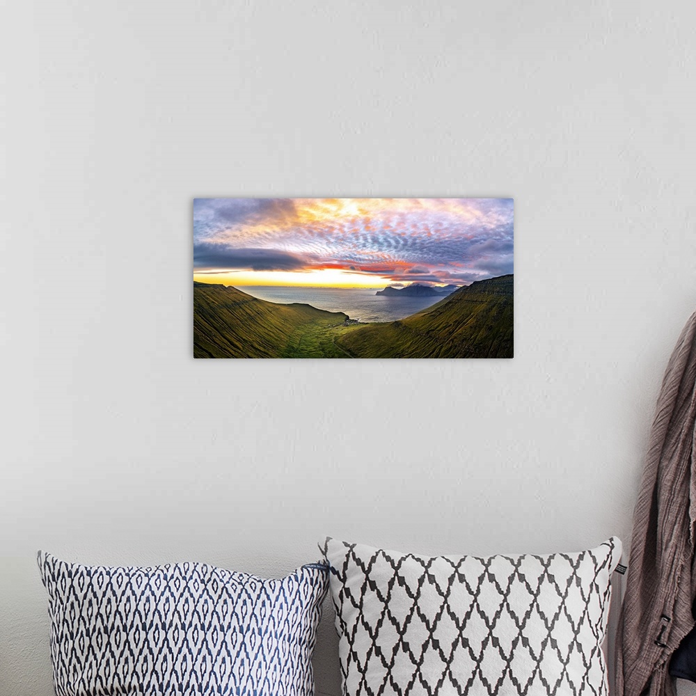A bohemian room featuring Dramatic sky with clouds at sunrise over the coastal village of Gjogv, aerial view, Eysturoy Isla...
