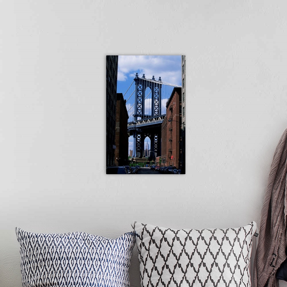A bohemian room featuring Empire State Building in distance seen through Manhattan Bridge, Brooklyn, New York
