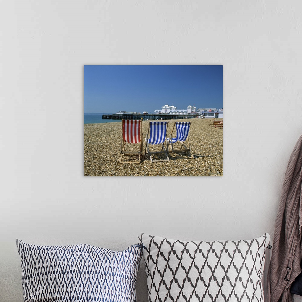 A bohemian room featuring Empty deck chairs on the beach and the Southsea Pier, Hampshire, England