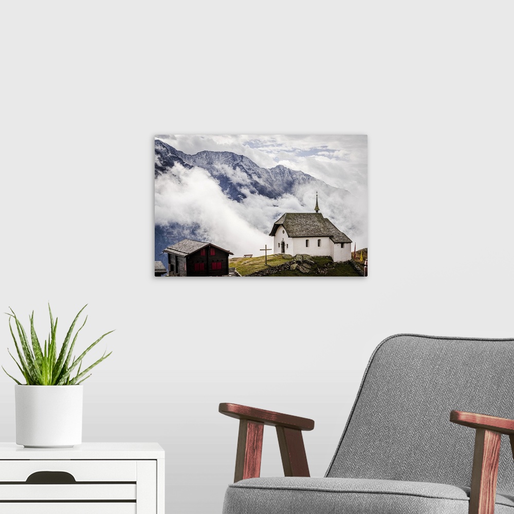 A modern room featuring Foggy sky over the small church in the alpine village of Bettmeralp, canton of Valais, Switzerlan...