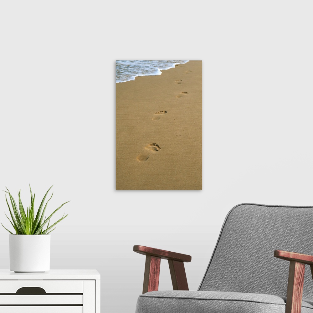 A modern room featuring Footprints in the sand on a beach and water's edge