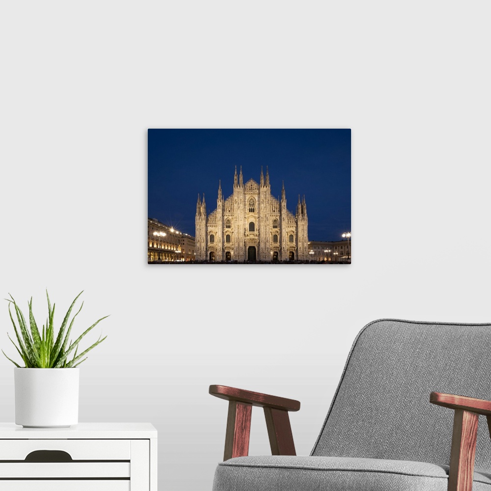 A modern room featuring Gothic spires on the facade of the Milan Cathedral in the Piazza del Duomo at dusk, Milan, Lombar...