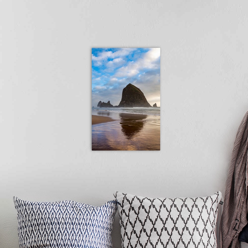 A bohemian room featuring Haystack Rock reflected on the shoreline at Cannon Beach on the Pacific Northwest coast, Oregon