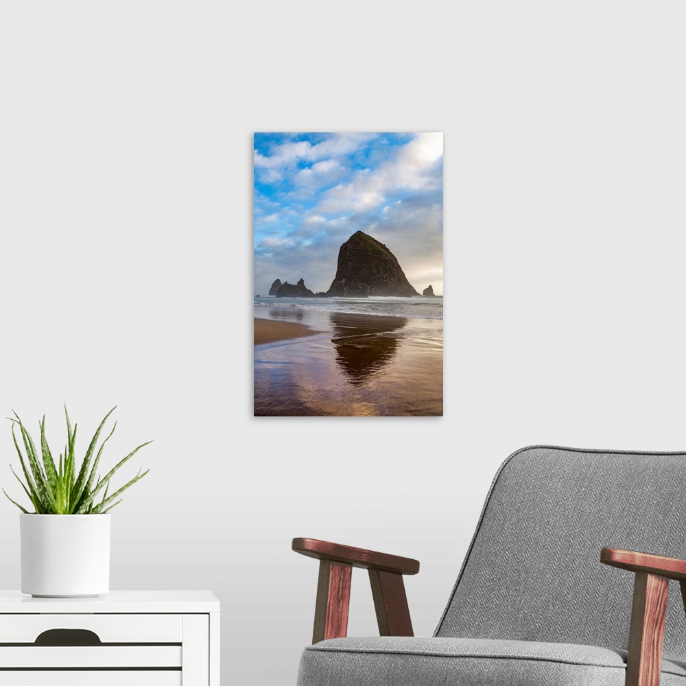A modern room featuring Haystack Rock reflected on the shoreline at Cannon Beach on the Pacific Northwest coast, Oregon