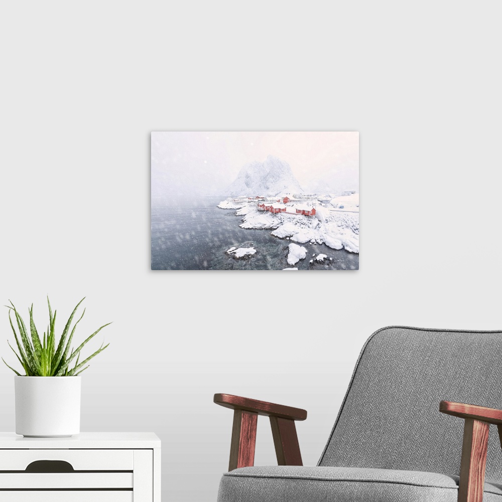 A modern room featuring Heavy snowfall on the fishermen's houses called Rorbu surrounded by the frozen sea, Hamnoy, Lofot...