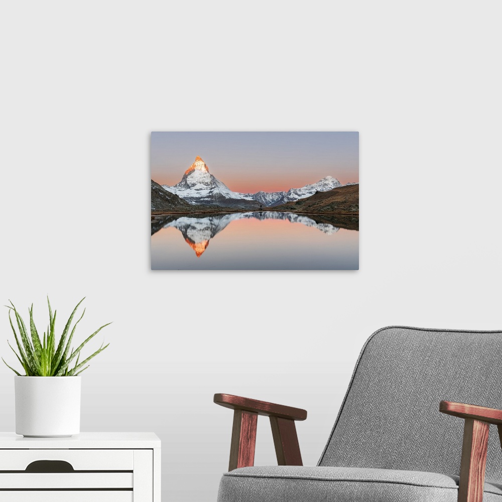 A modern room featuring Hiker admiring the Matterhorn reflected in the Riffelsee lake at sunrise, Gornergrat, Zermatt, ca...