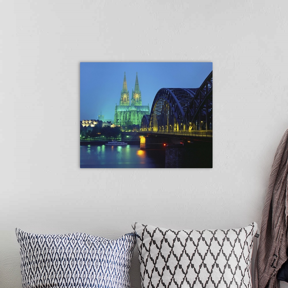 A bohemian room featuring Hohenzollernbrucke and the Cathedral Illuminated at Night, Cologne, Germany.