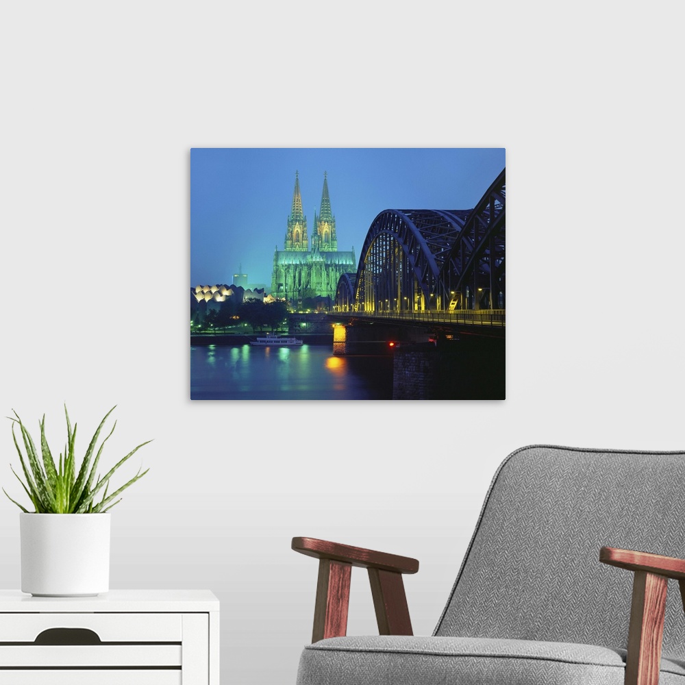 A modern room featuring Hohenzollernbrucke and the Cathedral Illuminated at Night, Cologne, Germany.