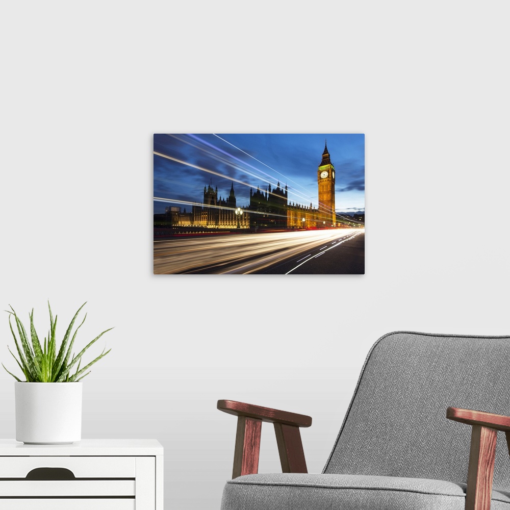 A modern room featuring Houses of Parliament and Big Ben floodlit at night with colourful light trails from passing traff...