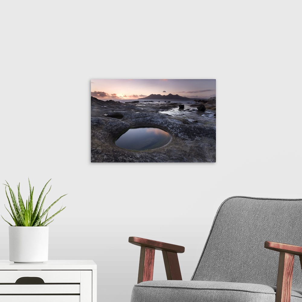 A modern room featuring Isle of Rum at sunset from rock formation at Laig Bay, Isle of Eigg, Scotland