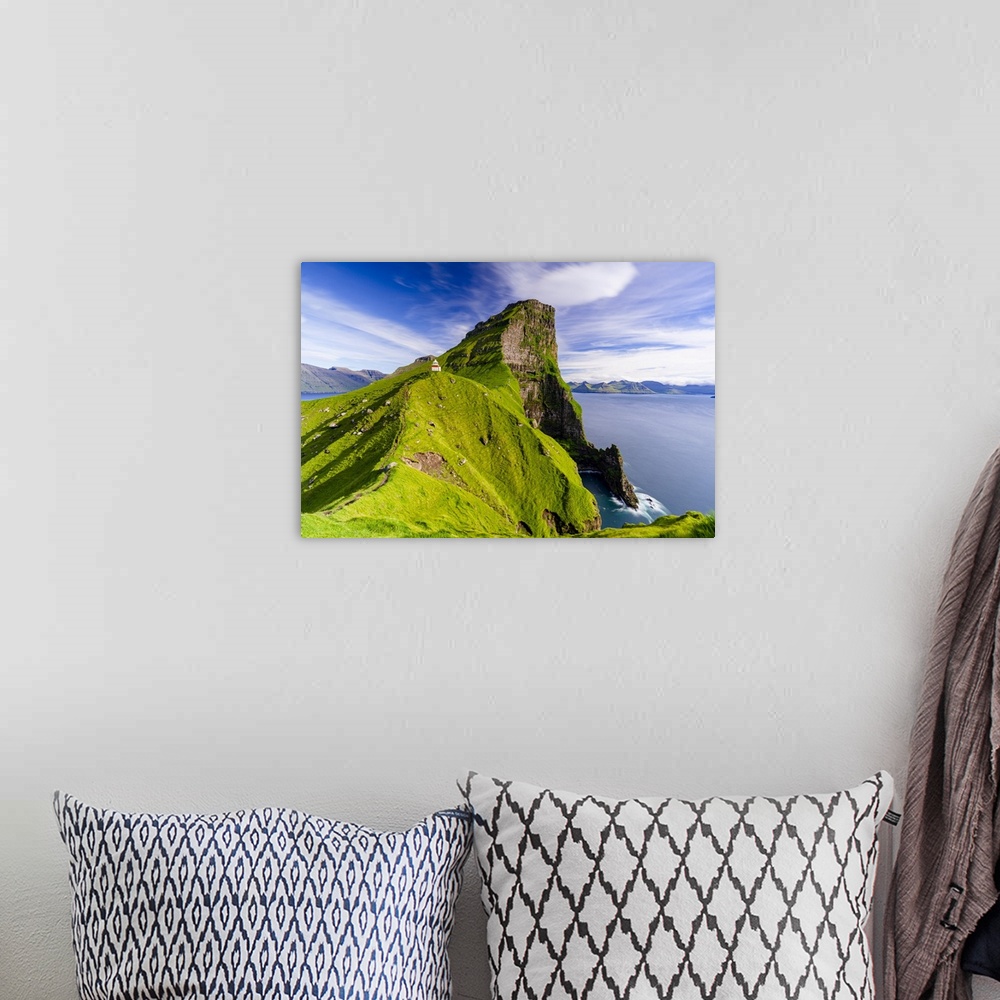 A bohemian room featuring Kallur lighthouse on cliffs covered with grass with Borgarin mountain peak on background, Kalsoy ...