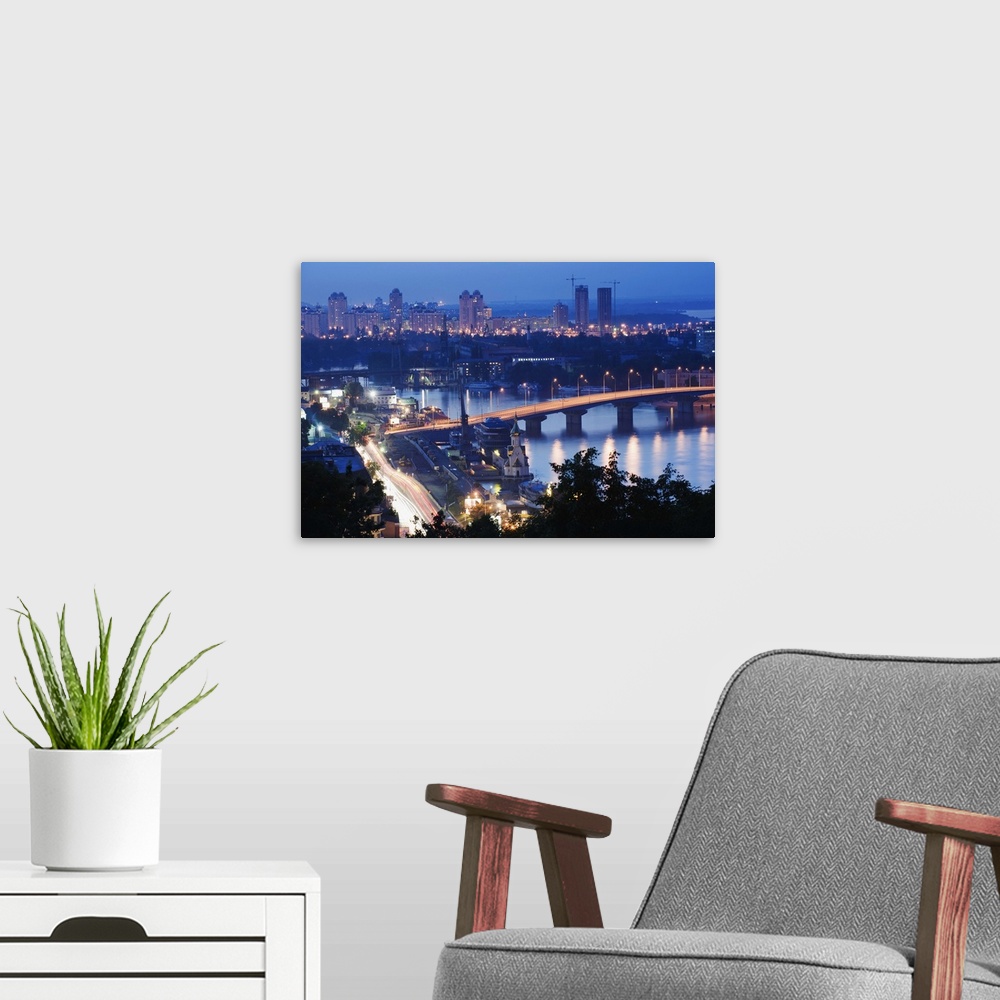 A modern room featuring Lights illuminating Podil district and Dnieper River area at night, Kiev, Ukraine