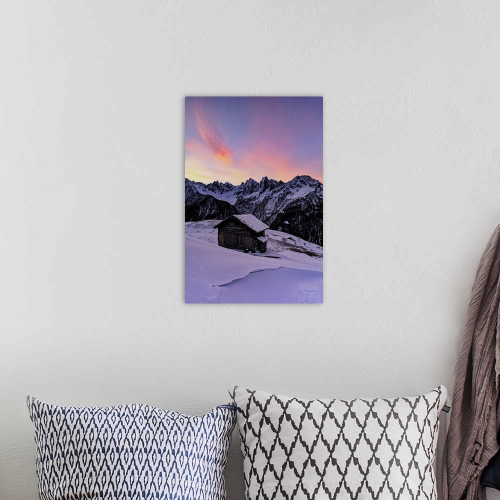 A bohemian room featuring Lone mountain hut in deep snow with majestic peaks in the background at dawn, Tombal, Val Bregagl...