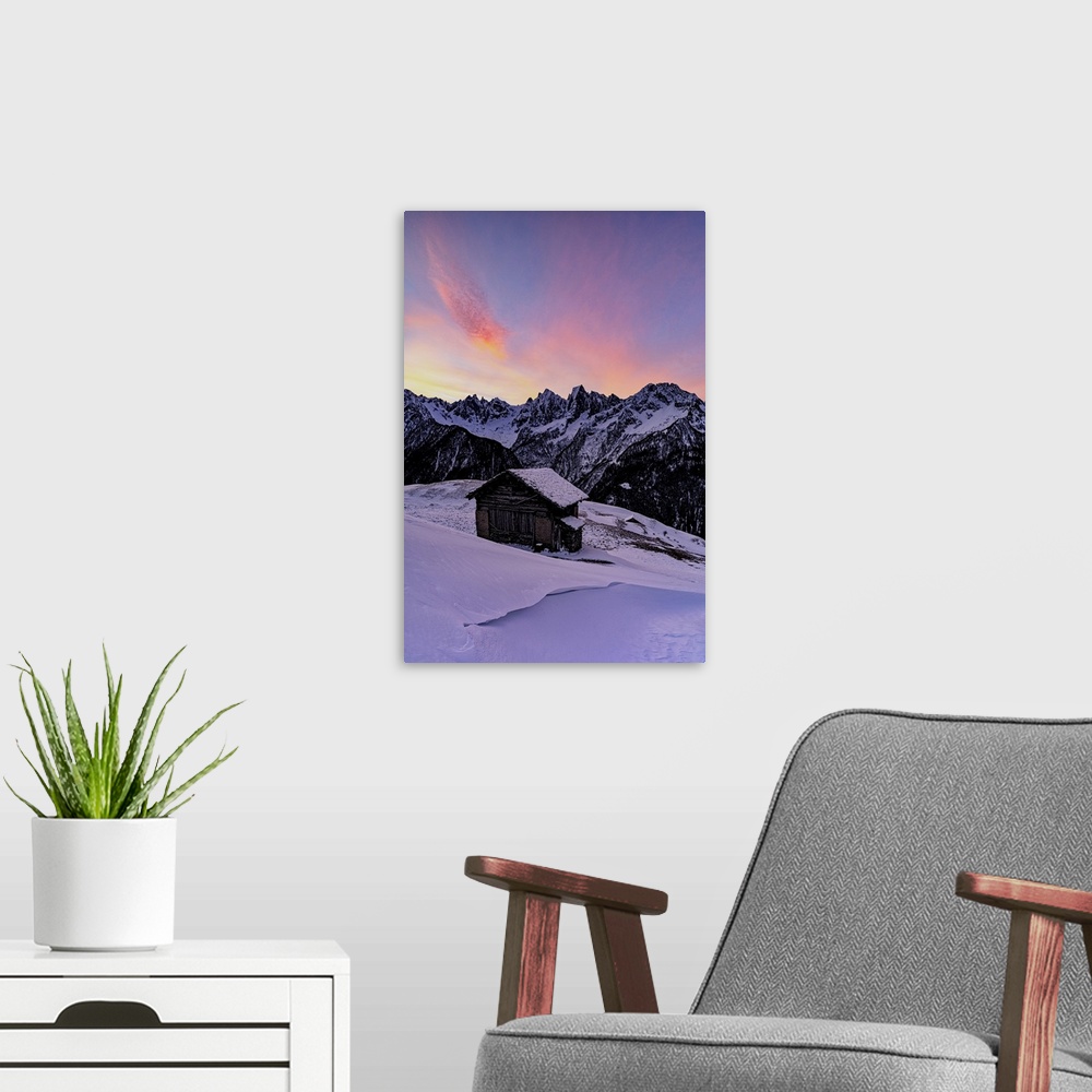 A modern room featuring Lone mountain hut in deep snow with majestic peaks in the background at dawn, Tombal, Val Bregagl...