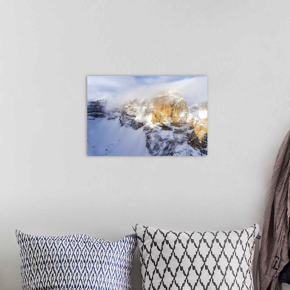 A bohemian room featuring Mist over the rocky peaks of Sella Group during a snowy winter, Gardena Pass, Dolomites, Trentino...