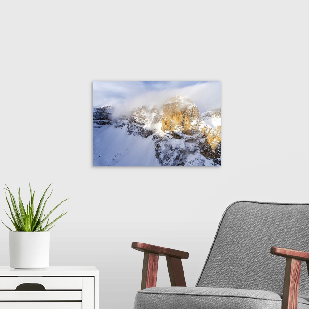 A modern room featuring Mist over the rocky peaks of Sella Group during a snowy winter, Gardena Pass, Dolomites, Trentino...