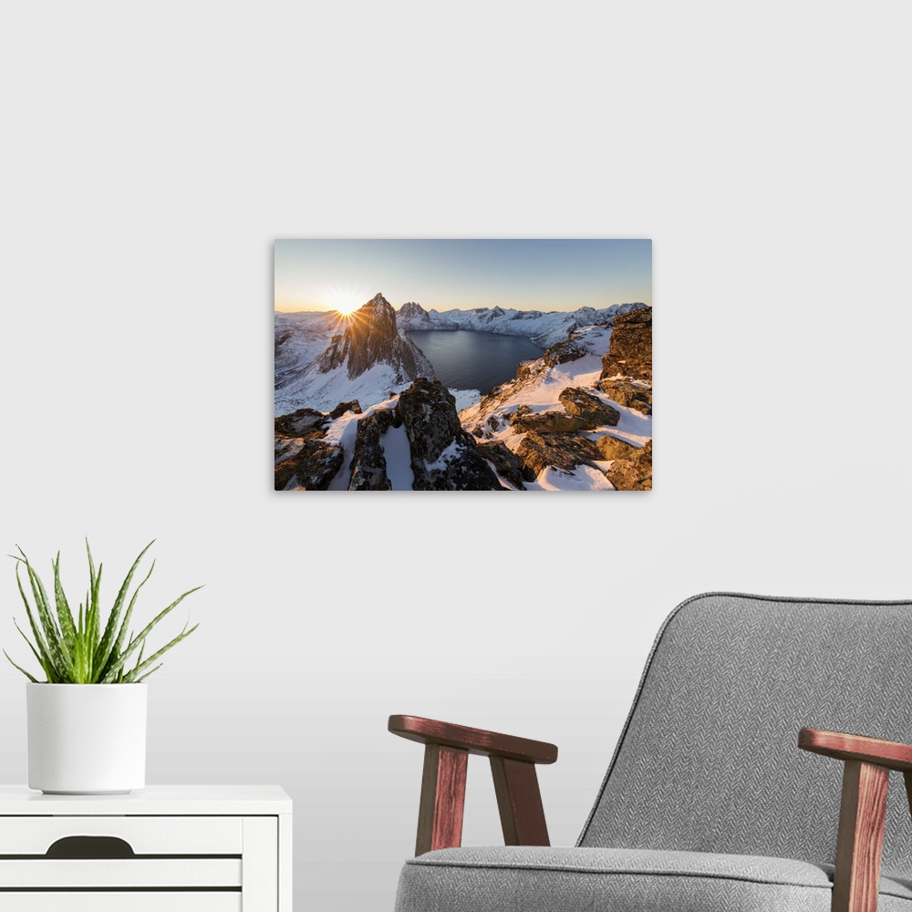 A modern room featuring First light of sunrise on Mount Segla and Mefjorden framed by the frozen sea seen from peak Heste...