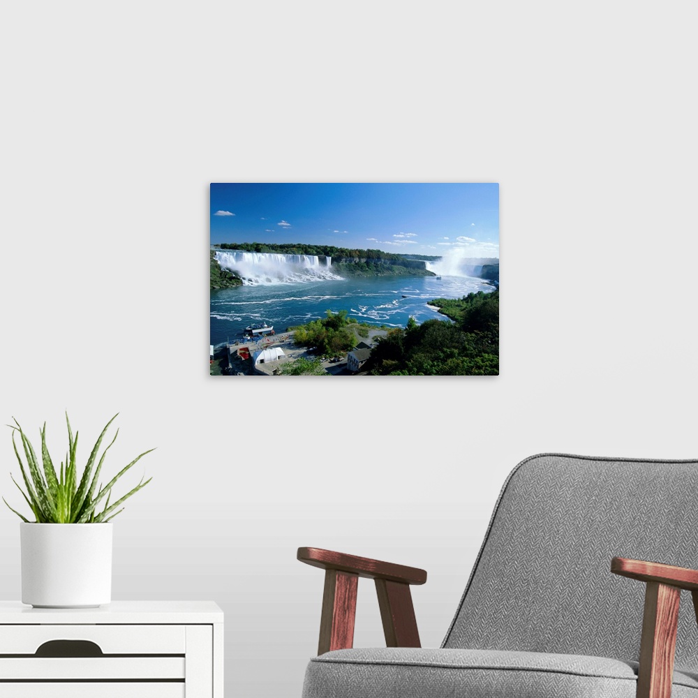 A modern room featuring Niagara Falls on the Niagara River that connects Lakes Ontario and Erie, American Falls on the le...