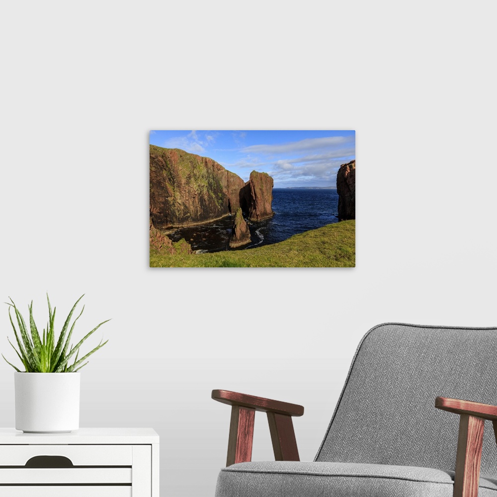 A modern room featuring North Ham, lichen covered huge red granite cliffs and stacks, Muckle Roe Island, Shetland Isles, ...