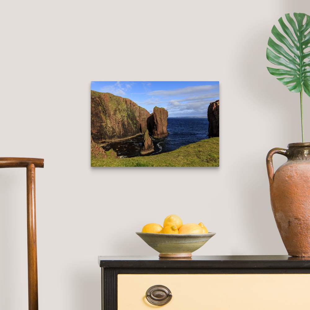 A traditional room featuring North Ham, lichen covered huge red granite cliffs and stacks, Muckle Roe Island, Shetland Isles, ...