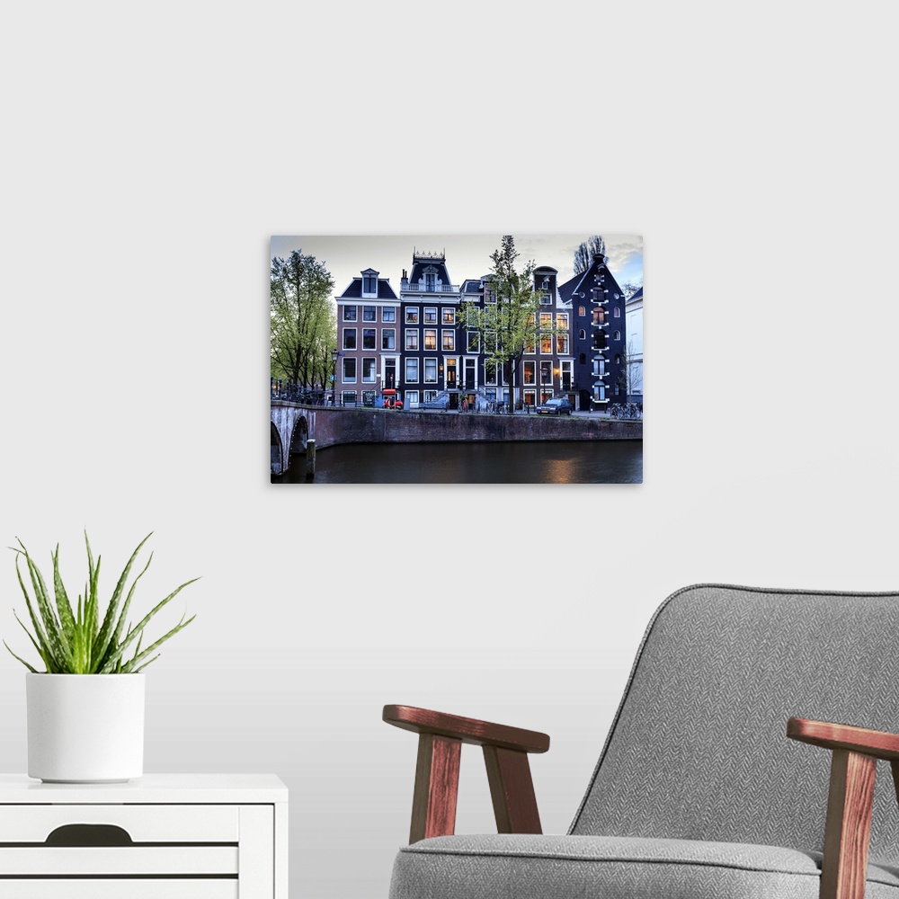 A modern room featuring Old gabled houses line the Keizersgracht canal at dusk, Amsterdam, Netherlands, Europe.